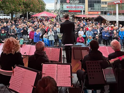 Eine Open-Air-Bühne in der Dresdner Altstadt während des Dixieland Festivals. Im Vordergrund steht ein Banner mit der Aufschrift „54. Internationales Dixieland Festival Dresden“. Dahinter ist eine Band auf einer Bühne zu sehen, umringt von zahlreichen Zuschauern vor der historischen Kulisse.