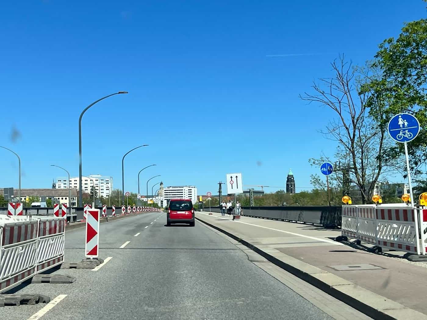 Blick aus der Windschutzscheibe eines Fahrzeugs auf eine Dresdner Straße mit Fahrbahnmarkierungen und Hinweisschildern im Bereich der Brückensperrung an der Ammonstraße.