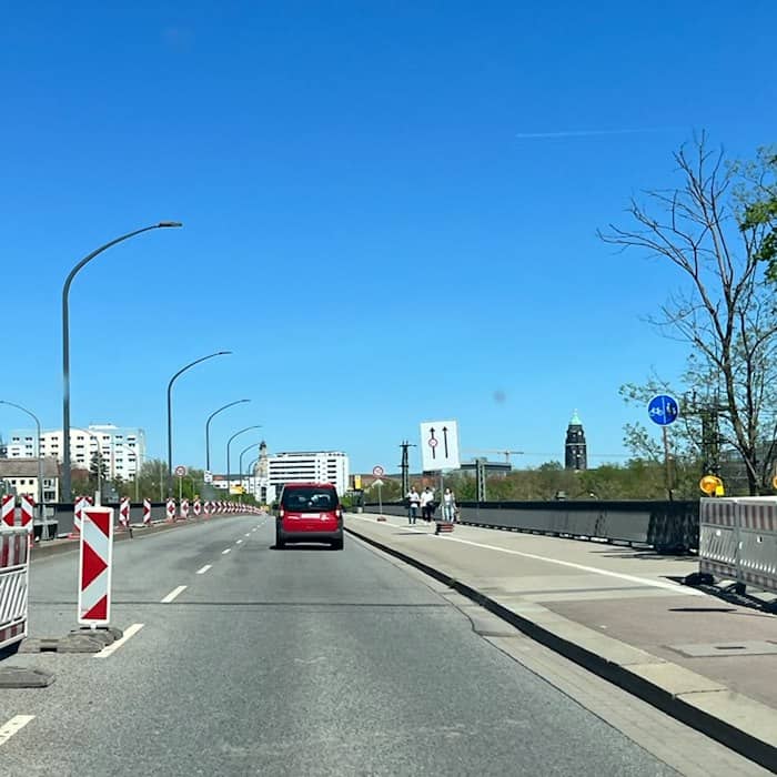 Blick aus der Windschutzscheibe eines Fahrzeugs auf eine Dresdner Straße mit Fahrbahnmarkierungen und Hinweisschildern im Bereich der Brückensperrung an der Ammonstraße.