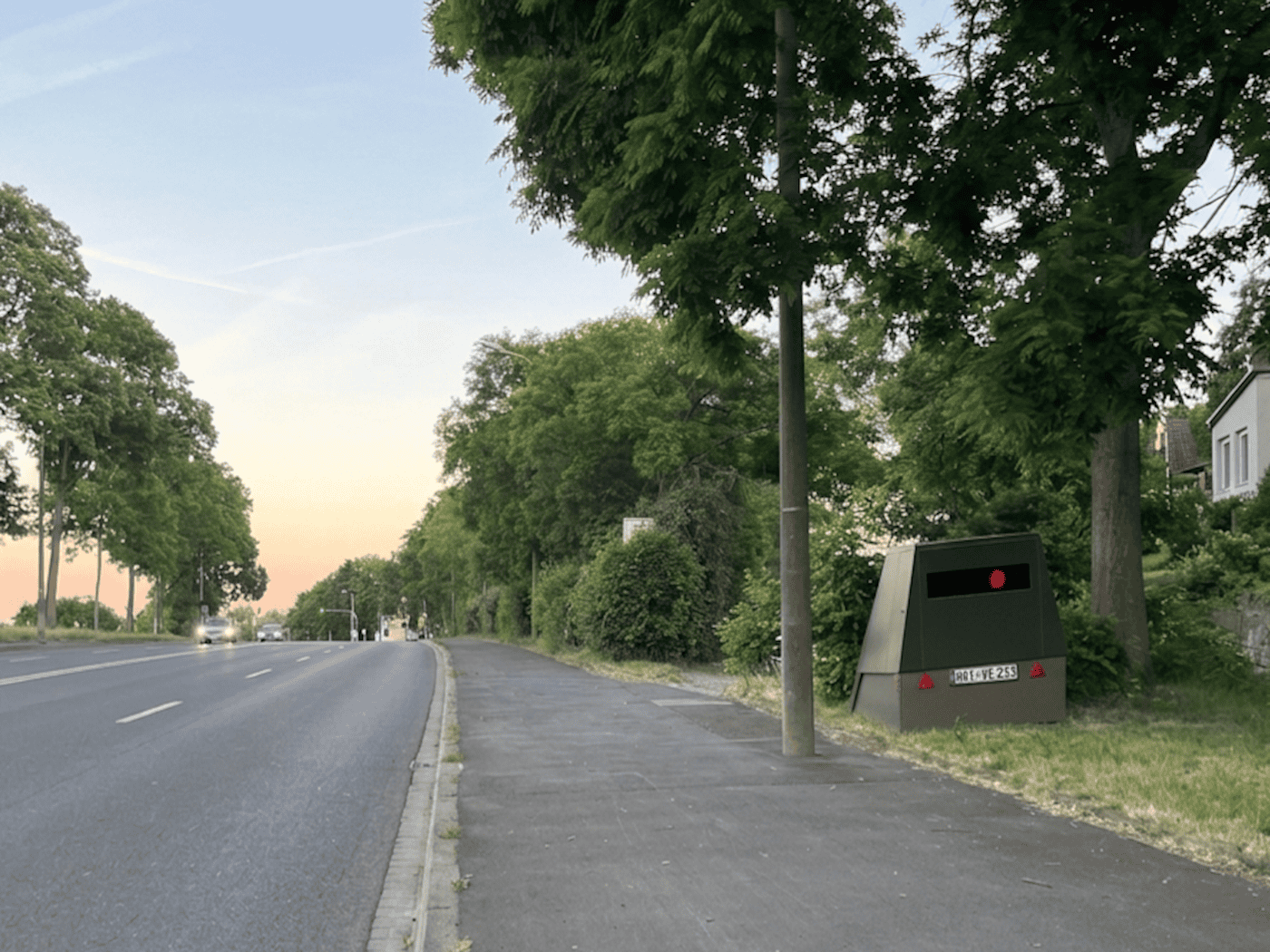 Der grüne Enforcement-Trailer „HWI-VE 213“ steht versteckt am Straßenrand der Meißner Landstraße in Dresden-Briesnitz.