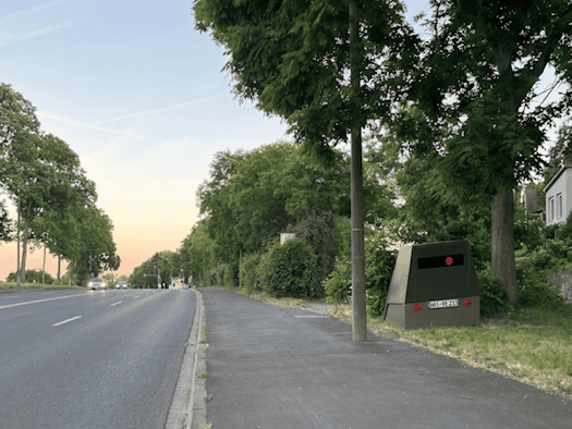Der grüne Enforcement-Trailer „HWI-VE 213“ steht versteckt am Straßenrand der Meißner Landstraße in Dresden-Briesnitz.