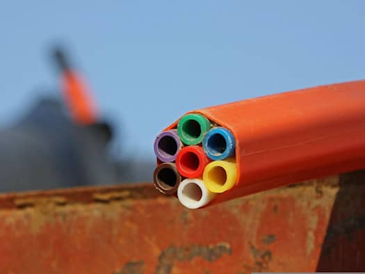 Nahaufnahme von leuchtenden, gebündelten Glasfaserkabeln, die das Prinzip der optischen Datenübertragung für Highspeed-Internet symbolisieren.