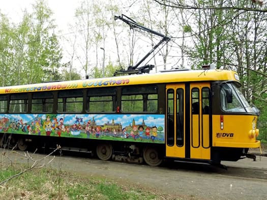 Die historische Kinderstraßenbahn „Lottchen“ fährt durch Dresden, geschmückt für eine Stadtrundfahrt.