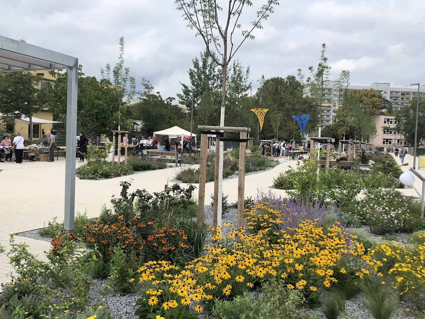 Die neugestaltete Lili-Elbe-Straße in Dresden-Johannstadt mit Grünanlagen, blühenden Blumenbeeten und Aufenthaltsbereichen im Jahr 2023.