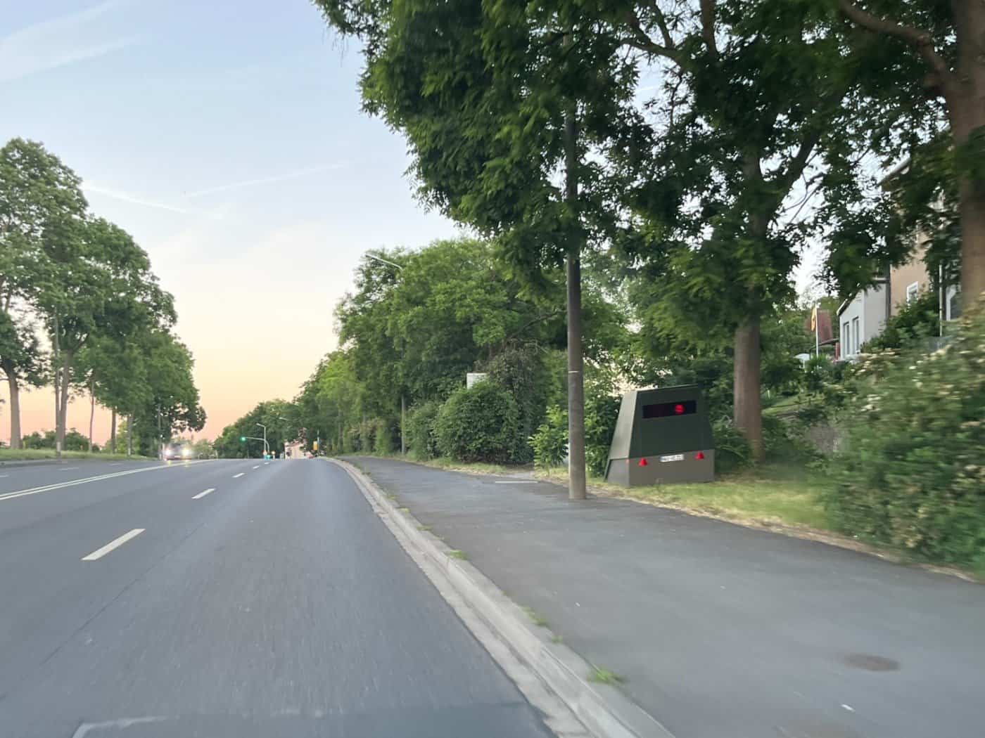 Der grüne Enforcement-Trailer „HWI-VE 213“ steht versteckt am Straßenrand der Meißner Landstraße in Dresden-Briesnitz.