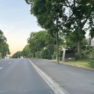 Der grüne Enforcement-Trailer „HWI-VE 213“ steht versteckt am Straßenrand der Meißner Landstraße in Dresden-Briesnitz.