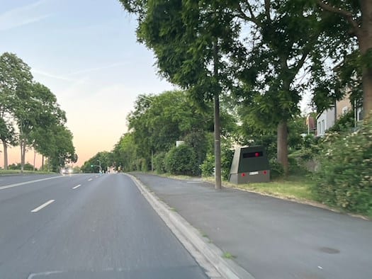 Der grüne Enforcement-Trailer „HWI-VE 213“ steht versteckt am Straßenrand der Meißner Landstraße in Dresden-Briesnitz.