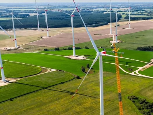 Landschaftsaufnahme mit zahlreichen Windrädern, teilweise im Bau