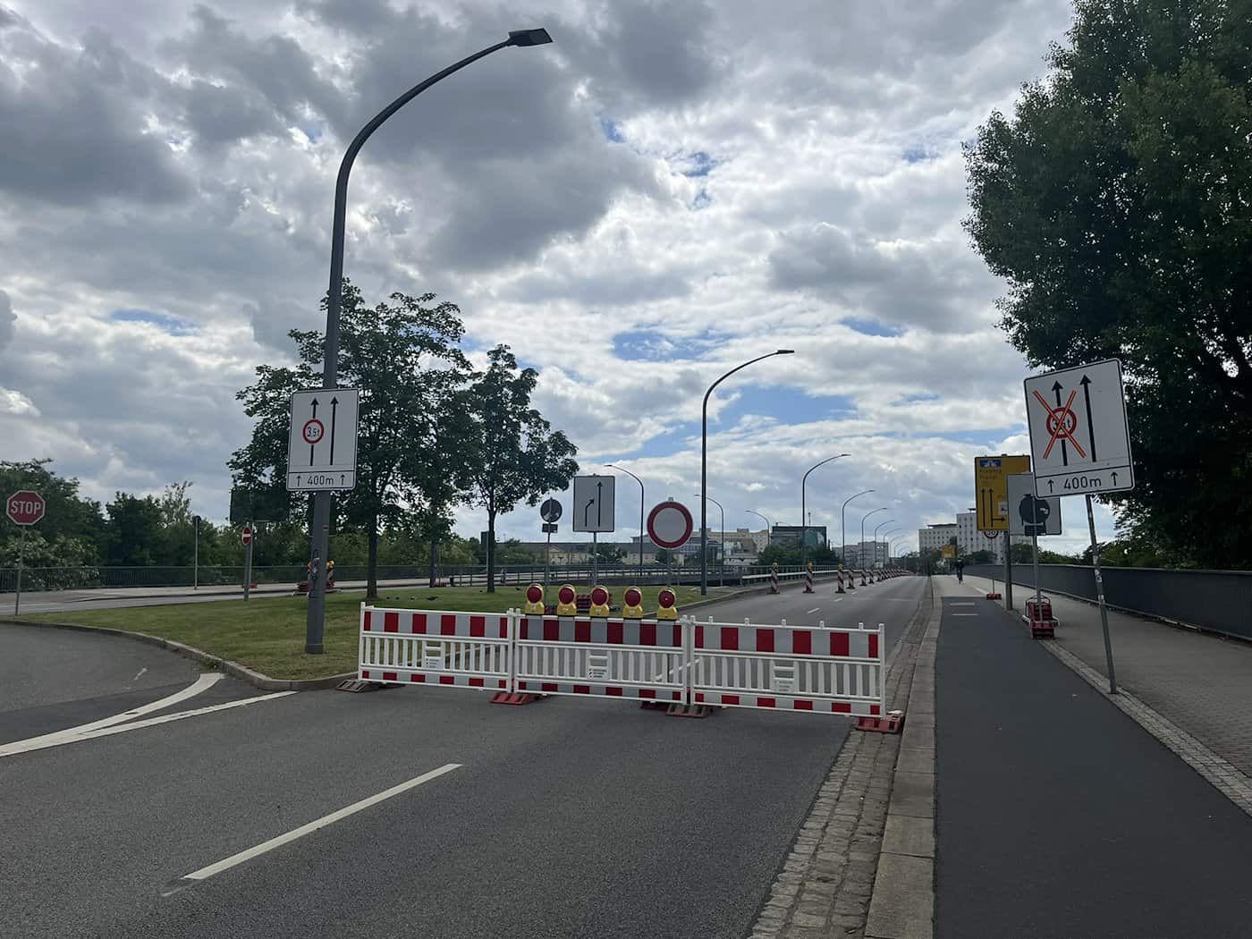 Rot-weiße Absperrgitter mit gelben Warnleuchten und diverse Verbotsschilder blockieren die Fahrbahn auf der Brücke Budapester Straße.