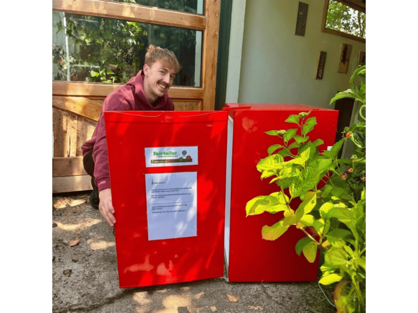 Foodsharing-Nutzer bedient sich am Kühlschrank Fair-Teiler im Garten der Dresdner Bürgerstiftung