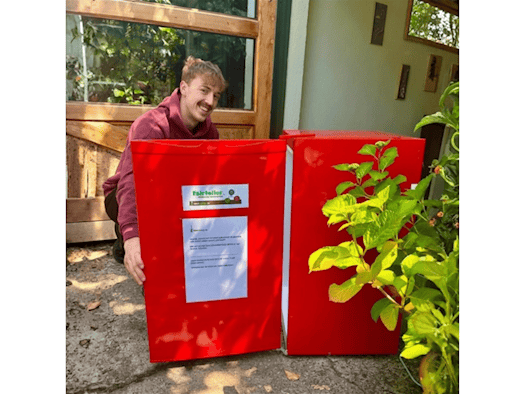 Foodsharing-Nutzer bedient sich am Kühlschrank Fair-Teiler im Garten der Dresdner Bürgerstiftung
