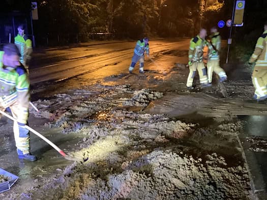 Einsatzkräfte der Feuerwehr Dresden räumen bei Nacht Schlamm und Geröll von der Bautzner Straße in Höhe der Haltestelle Mordgrundbrücke.