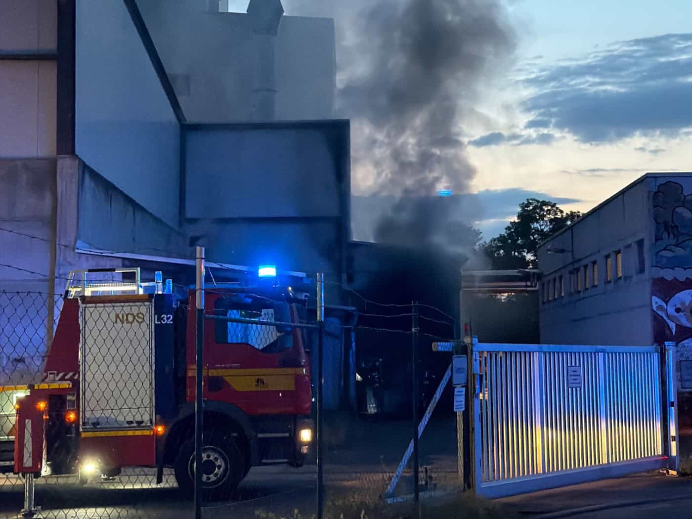 Einsatzfahrzeuge der Feuerwehr bei der Brandbekämpfung am Heizkraftwerk am Lugaer Graben in Dresden-Großschachwitz mit sichtbarer Rauchentwicklung.
