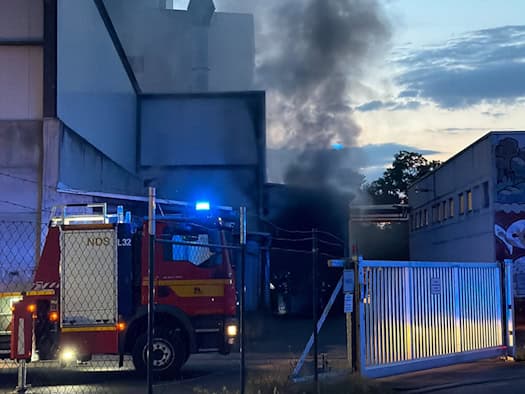 Einsatzfahrzeuge der Feuerwehr bei der Brandbekämpfung am Heizkraftwerk am Lugaer Graben in Dresden-Großschachwitz mit sichtbarer Rauchentwicklung.