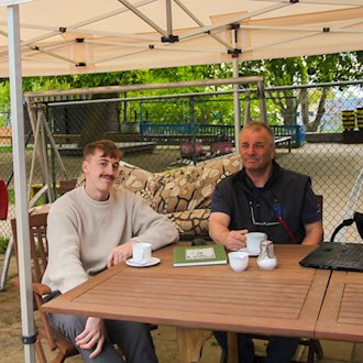 Marius Fischer und Andreas Färber sitzen gemeinsam bei einem Kaffee im Kindercafé Mücke