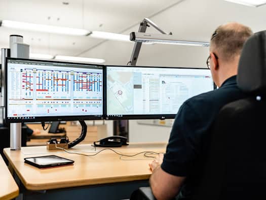 Ein Mitarbeiter der Dresdner Leitstelle sitzt vor mehreren Bildschirmen mit Einsatzplänen und digitalen Karten zur Koordination von Rettungseinsätzen.