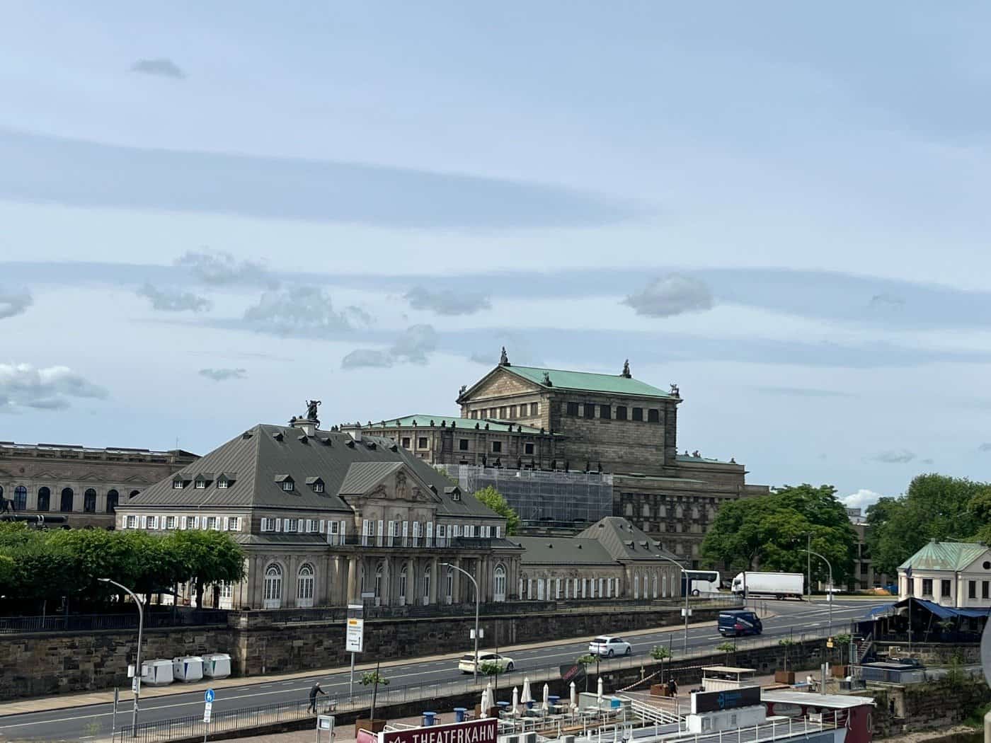 Das historische Gebäude Italienisches Dörfchen in Dresden an der Elbe mit der Semperoper im Hintergrund.