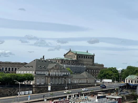 Das historische Gebäude Italienisches Dörfchen in Dresden an der Elbe mit der Semperoper im Hintergrund.