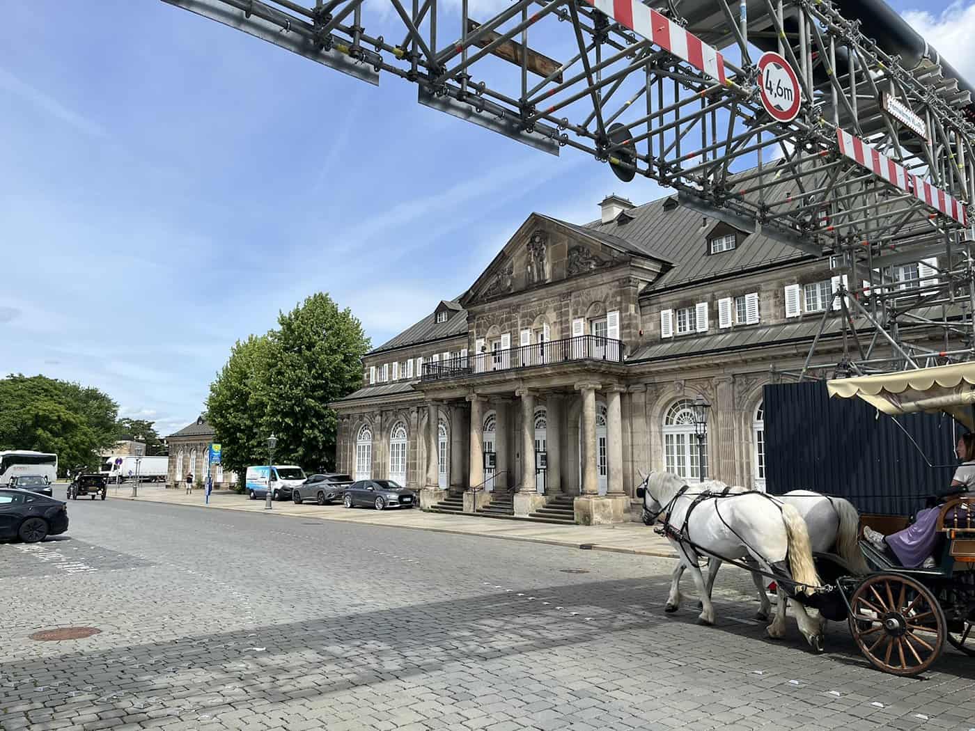 Außenansicht des Italienischen Dörfchens in Dresden mit großen grünen Bäumen vor der Sandsteinfassade.