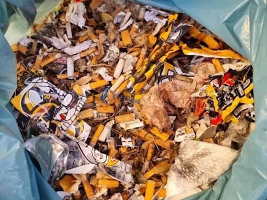Foto: Blick in eine blaue Plastik-Mülltüte. Darin finden sich sehr viele Zigarettenstummel und anderer Müll.