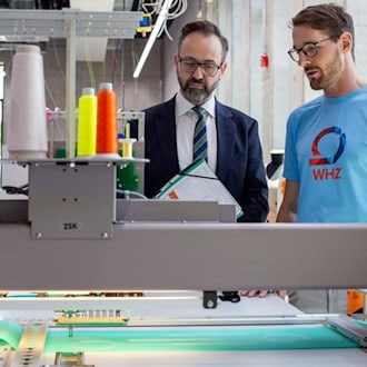 Sebastian Gemkow (l.) und Philipp Thiem an der Mehrkopfstickmaschine im neuen Technikum. Dort werden Ideen für nachhaltige Textilien entwickelt.