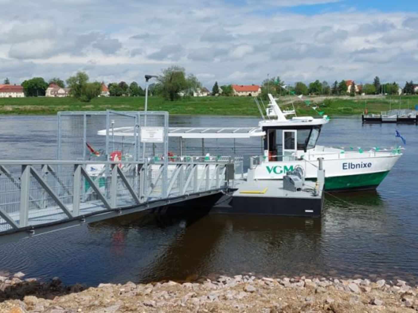 Foto: Eine kleine Personenfähre mit der Beschriftung "Elbnixe" liegt in einem Fluss an einem Anleger