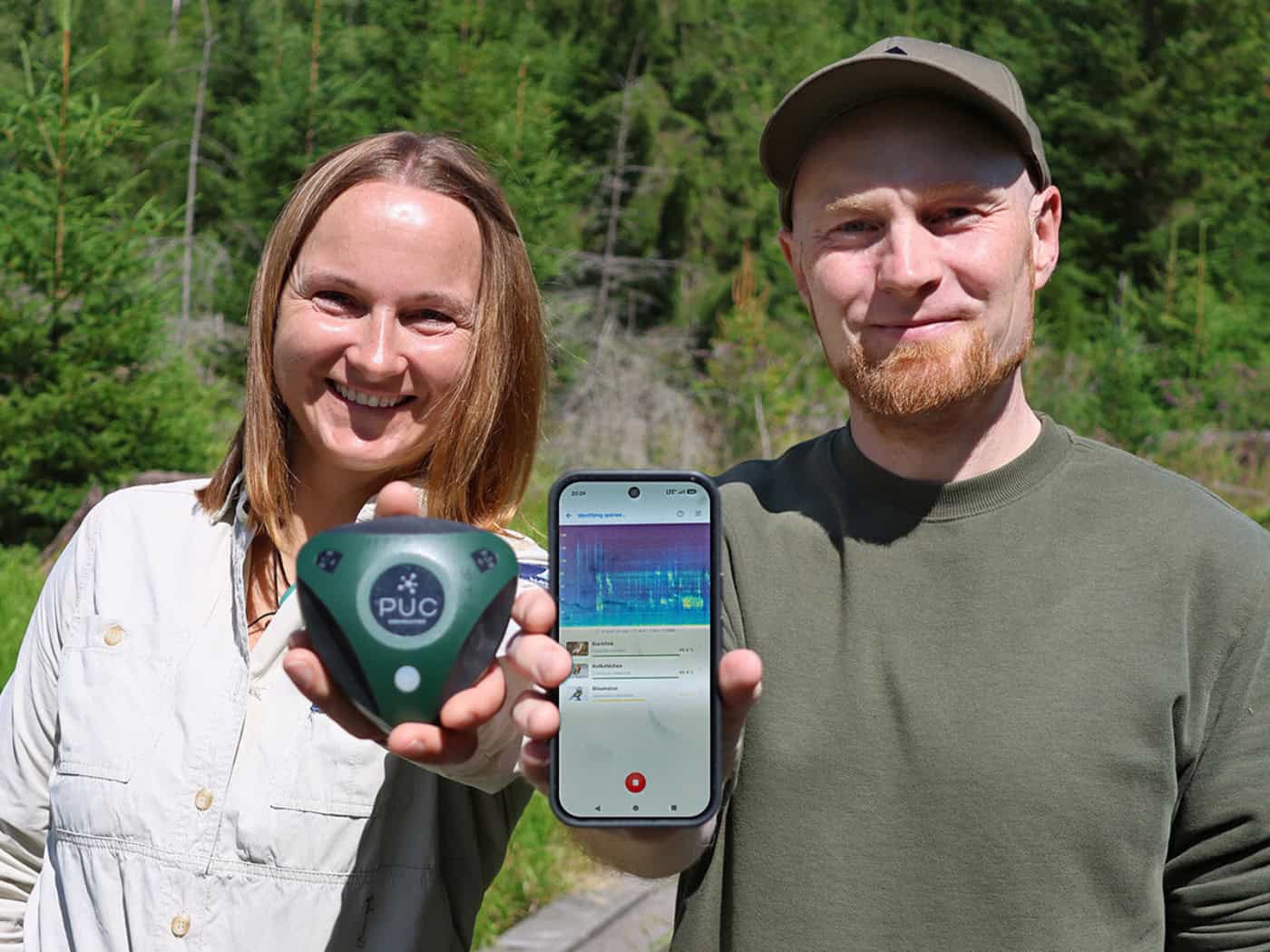 Martina Buchna, a ranger at the Bavarian Forest National Park, shows Dr. Stefan Kahl from Chemnitz University of Technology an audio logger used to record sounds in the forest.