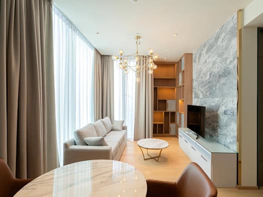Vorhänge hängen gleichmäßig an einer unsichtbaren Schiene in einem modernen Wohnzimmer
