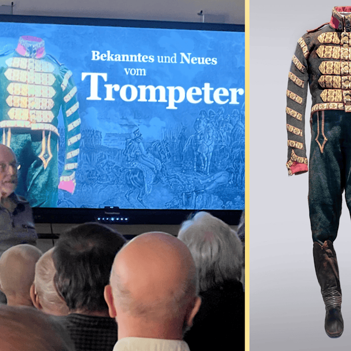 Zusammensetzung zweier Bilder: Links ein Redner vor Publikum, im Hintergrund eine Präsentation mit der Schrift "Bekanntes und Neues vom Trompeter"; Rechts eine prächtig verzierte, rot-blaue, historische Uniform.