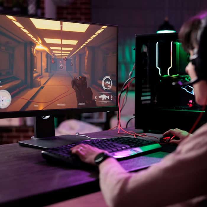 Ein Gamer in Leipzig spielt ein actionreiches Online-Spiel an einem modernen PC mit RGB-Beleuchtung.