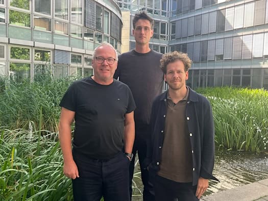 Stefan Burgard, Tobias Mansperger und Frank Großkopf (v. l.) von der Planergemeinschaft LAP und Querfeldeins stehen vor einer Glasfassade im Außenbereich und blicken in die Kamera.