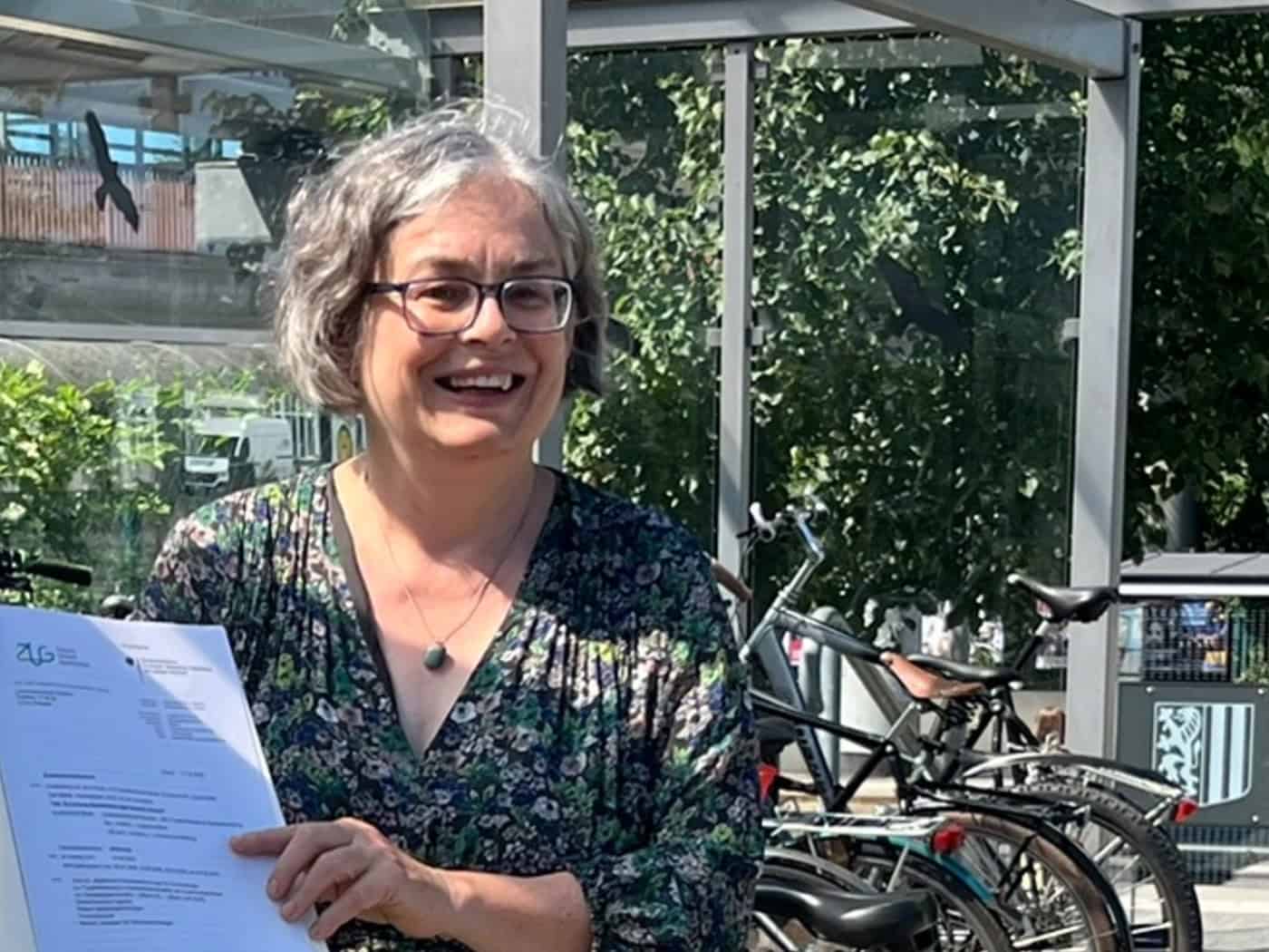 Dresdens Umweltbürgermeisterin Eva Jähnigen steht lächelnd an einer Fahrradstation.