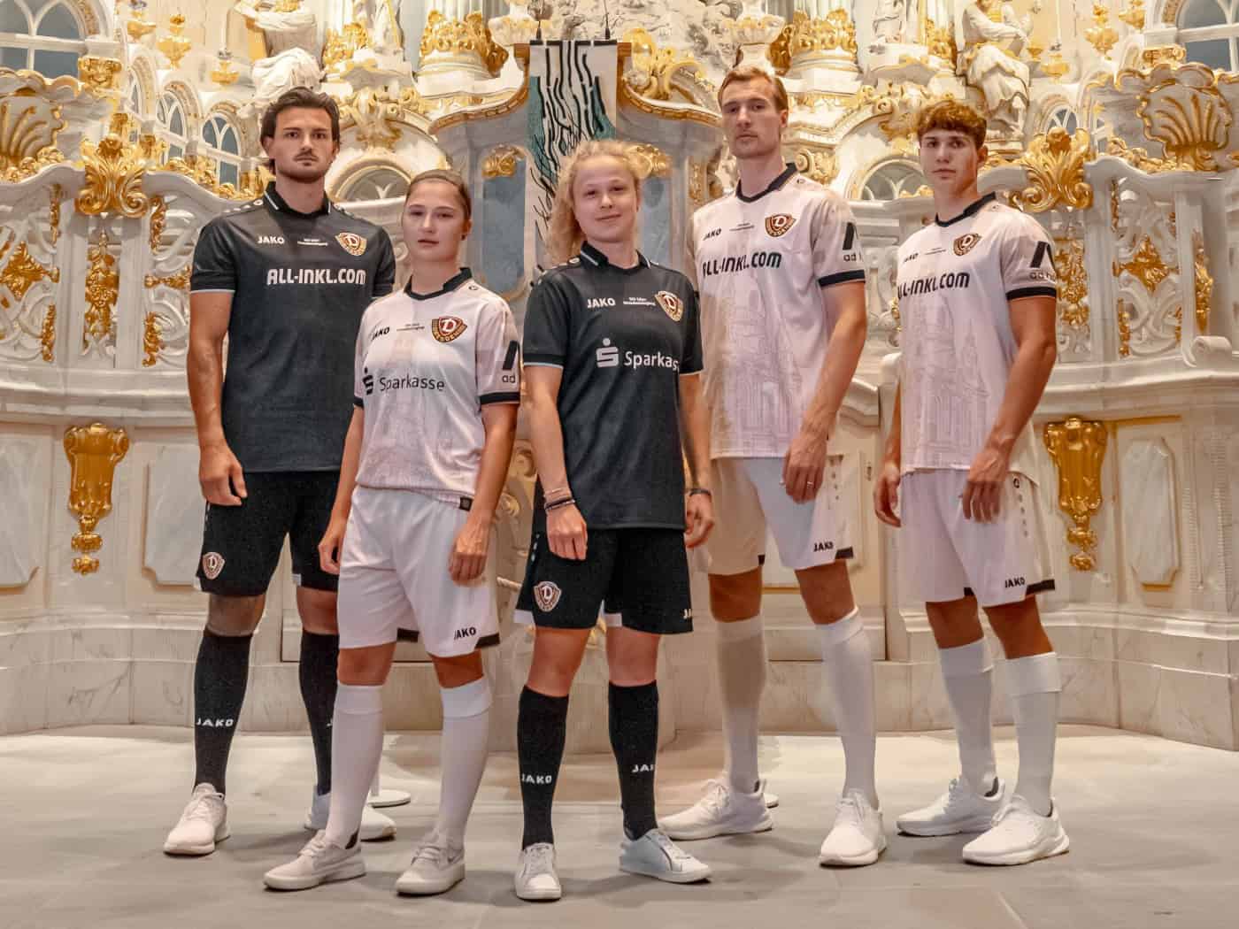 Fünf Spielerinnen und Spieler von Dynamo Dresden stehen vor dem prunkvollen, gold-weißen Altar der Dresdner Frauenkirche und präsentieren die neuen Sondertrikots in Sandstein-Optik und dunklem Torwart-Design.