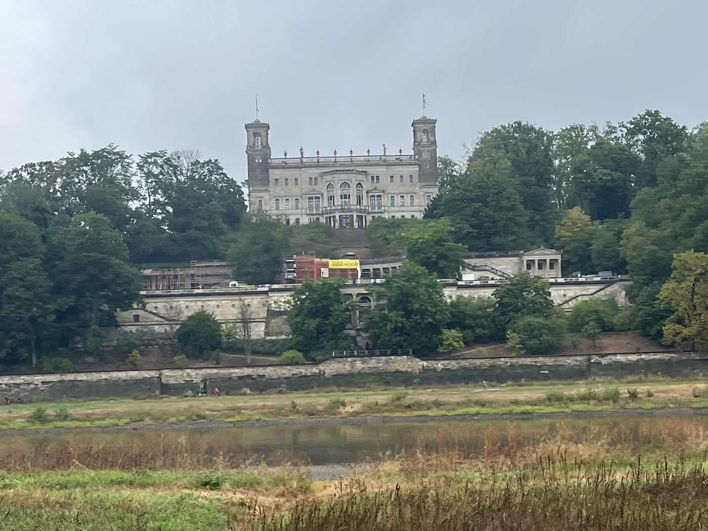 Fernansicht von Schloss Albrechtsberg über die Elbwiesen. An den Hangterrassen befindet sich die Baustelle des Römischen Bades, an dessen Kolonnaden das Gerüst bereits abgebaut wurde.
