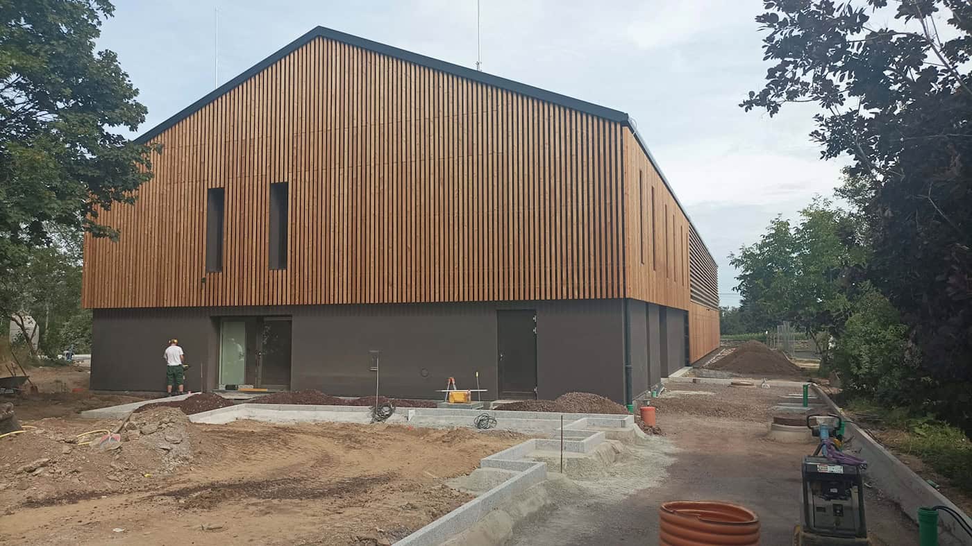 Neue Einfeld-Sporthalle des BSZ Agrarwirtschaft in Dresden-Altroßthal Die neue Sporthalle des BSZ Agrarwirtschaft in Dresden-Altroßthal mit einer hellen Holzfassade und Steildach. Im Vordergrund laufen noch letzte Arbeiten am Außengelände.