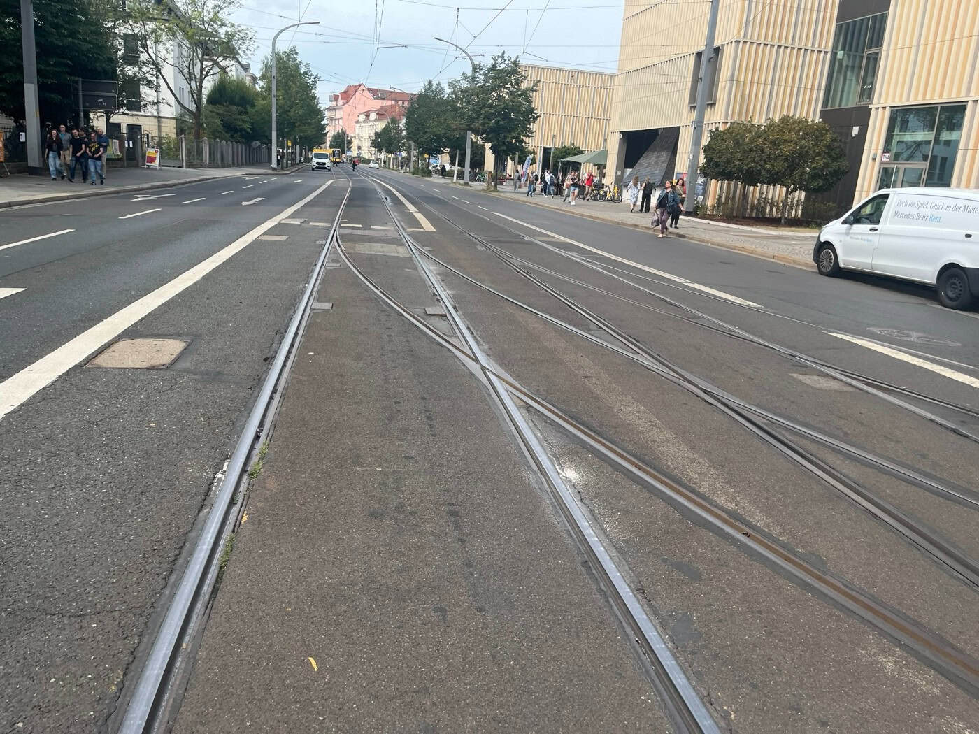 Blick entlang der Antonstraße in Dresden auf im Asphalt verlegte Straßenbahngleise und eine Gleisweiche. Rechts stehen moderne Gebäude, im Hintergrund verlaufen die Schienen in Richtung Bahnhof Neustadt.