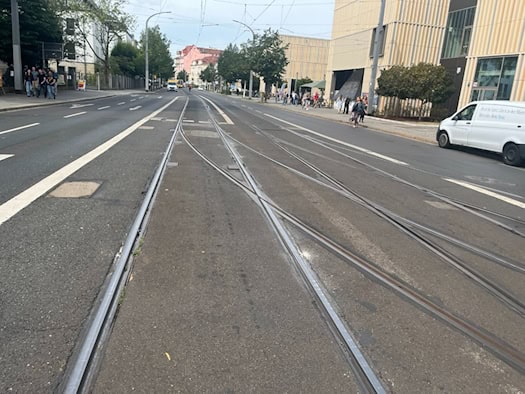 Blick entlang der Antonstraße in Dresden auf im Asphalt verlegte Straßenbahngleise und eine Gleisweiche. Rechts stehen moderne Gebäude, im Hintergrund verlaufen die Schienen in Richtung Bahnhof Neustadt.