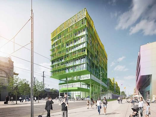 Moderne Architekturdarstellung des geplanten Simmel-Terminals: Ein mehrstöckiges Gebäude mit markant vorkragenden Obergeschossen und auffälliger grün-gelber Fassade. Im Vordergrund belebter Gehweg, links Gleisanlagen am Hauptbahnhof Dresden.