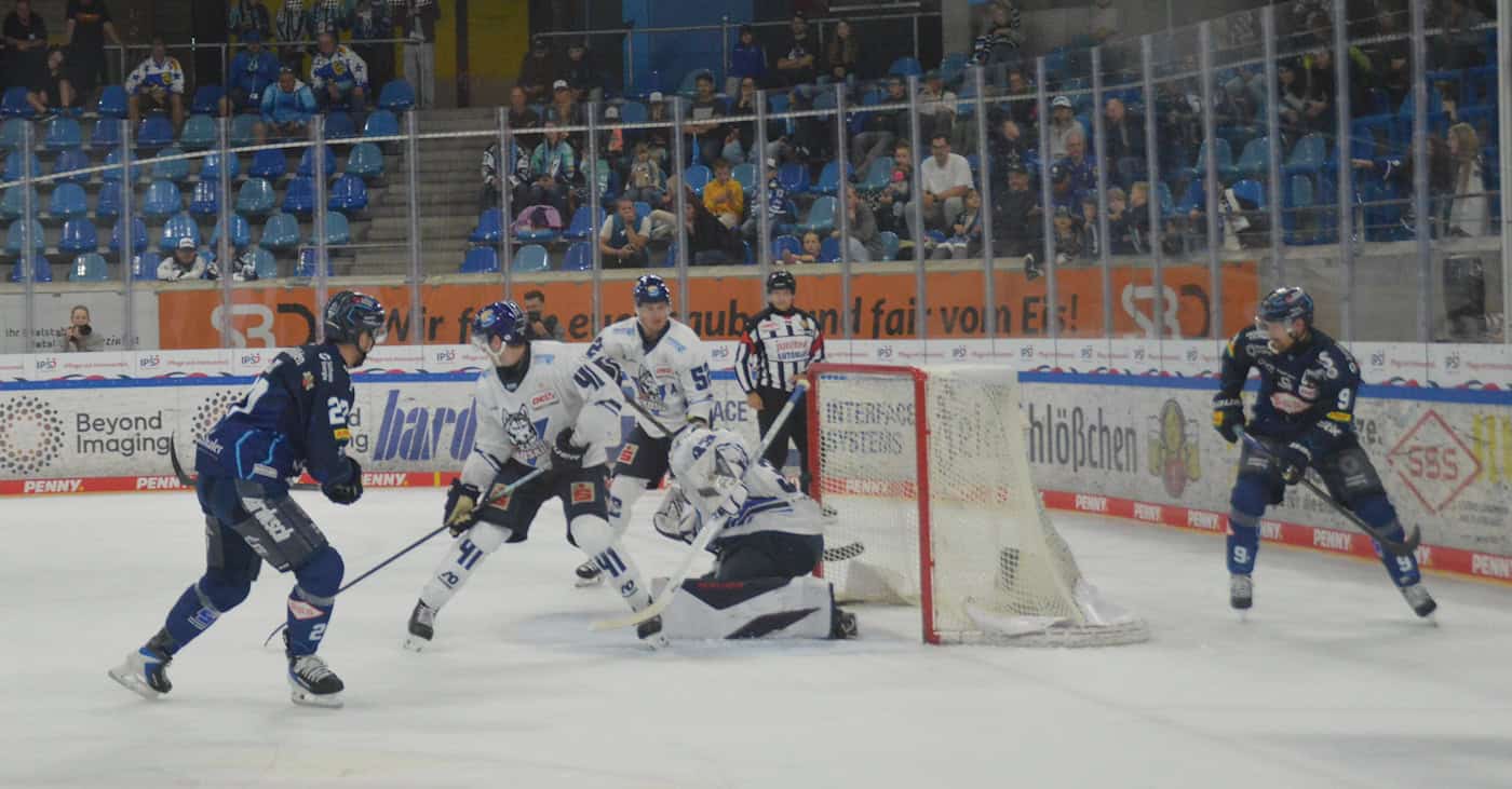 Torszene zum 3:0 der Dresdner Eislöwen im Testspiel gegen die Kassel Huskies Spielszene im Torraum: Ein Eislöwen-Stürmer schießt auf das Tor der Kassel Huskies, während der Kasseler Torwart auf dem Eis liegt und die Verteidiger versuchen zu klären.