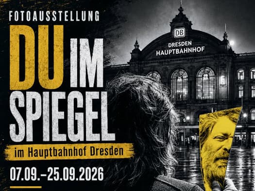 Veranstaltungsplakat zur Fotoausstellung „Du im Spiegel“ im Dresdner Hauptbahnhof (07.09.–25.09.2026). Zu sehen ist die Rückansicht einer Person, die ein Spiegelfragment mit dem Gesicht eines Mannes hält. Im Hintergrund ist die Fassade des Hauptbahnhofs abgebildet.