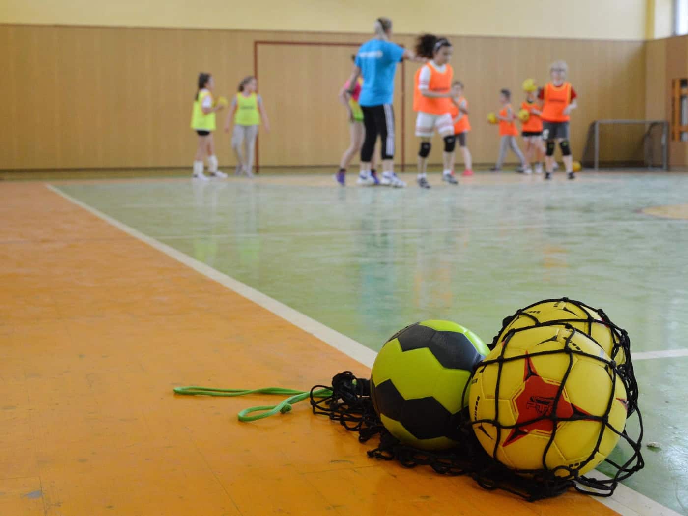 Kinder beim Handballtraining in einer Sporthalle
