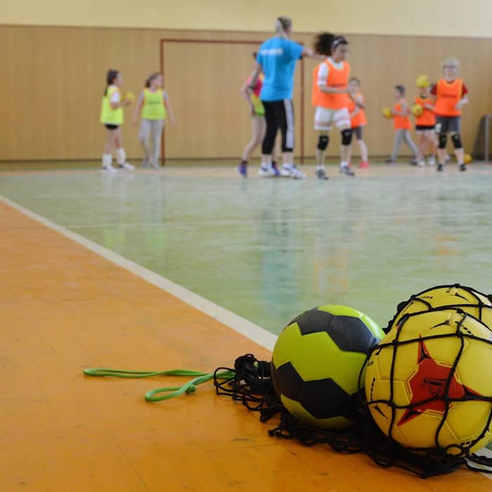 Kinder beim Handballtraining in einer Sporthalle
