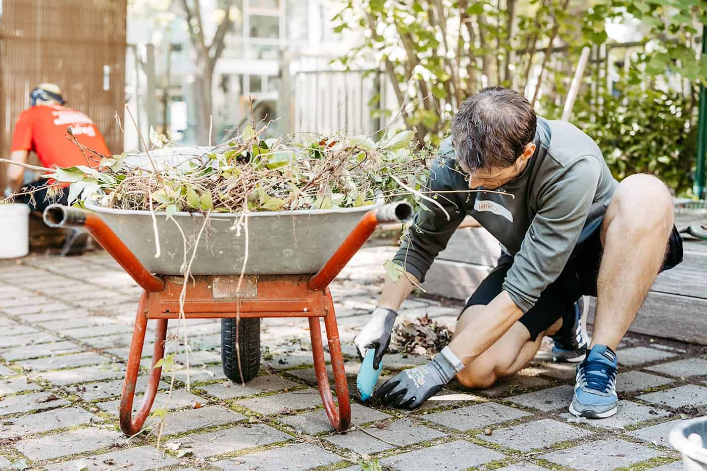 Ein Mitarbeitender hilft ehrenatmlich im Kinder- und Jugendtreff bei Gartenarbeiten