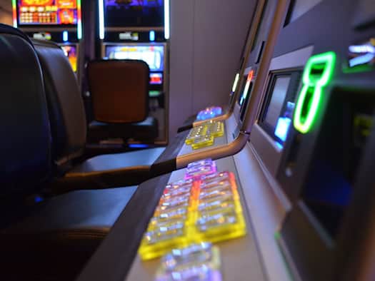 Nahaufnahme eines Spielautomaten mit leuchtenden Knöpfen und einer digitalen Anzeige in einem Casino.