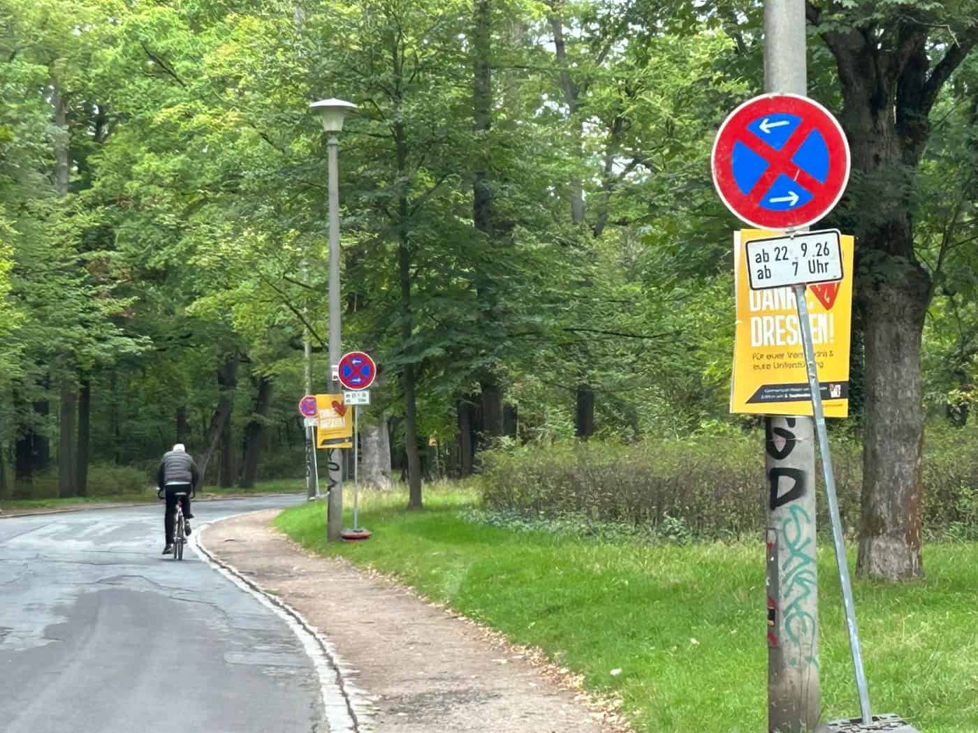 Grüner Straßenverlauf des Lothringer Wegs mit Bäumen und einem Radfahrer im Hintergrund. Im Vordergrund steht ein absolutes Halteverbotsschild mit dem Zusatzschild „ab 22.9.26 ab 7 Uhr“.