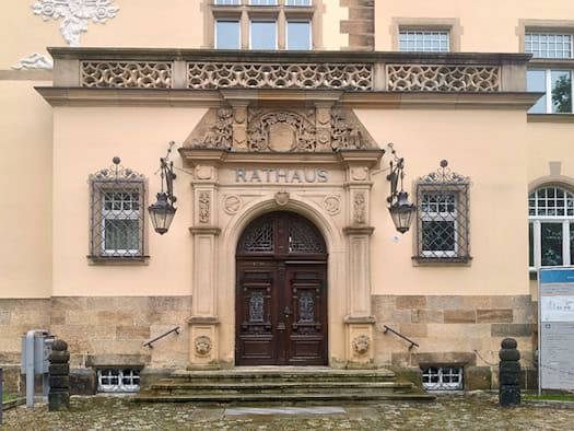 Verziertes Eingangsportal des Rathauses Radebeul mit Freitreppe und zwei Laternen.
