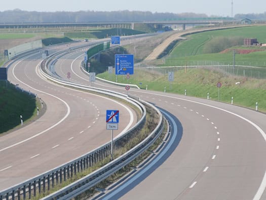 Blick auf die geschwungene A72 bei Rochlitz mit getrennten Fahrbahnen, Leitplanken und blauen Wegweisern, aufgenommen 2013.