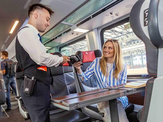 Zugbegleiter der Tschechischen Bahn bei der Fahrkartenkontrolle in einem Reisezug.