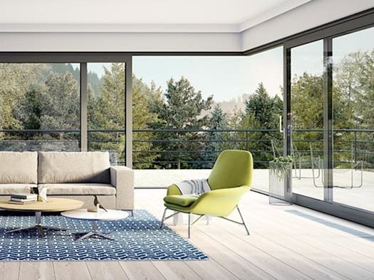 Wohnzimmer mit großen modernen Fenstern und Blick in bewaldete Umgebung