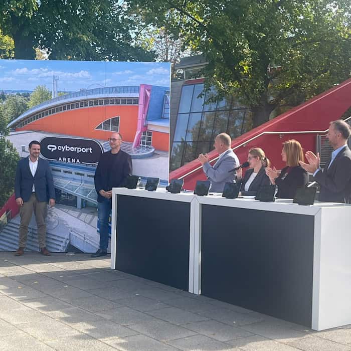 Offizielle Präsentation vor der Dresdner Arena: Links steht eine Fotowand mit der Abbildung der Sporthalle und dem neuen Schriftzug „cyberport ARENA“. Rechts klatschen Vertreter von Stadt und Sponsor an einem weißen Stehpult.